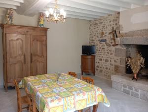 a dining room with a table and a fireplace at La garçonnière in Gesvres