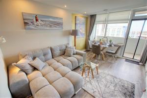 a living room with a large couch and a table at Ferienpark - Haus K, App 0K0801 in Heiligenhafen
