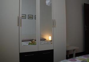 een witte kast met een spiegel in een slaapkamer bij Apartment Spanjol in Banjol