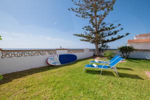a blue chair and a surfboard in a yard at Villa Girasol in Calahonda