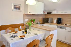 a kitchen with a table with a white table cloth at Ferienresidenz Chiemseestrand - Apartment 31 in Chieming