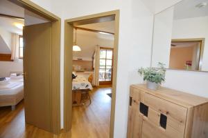 a room with a door open to a kitchen with a table at Ferienresidenz Chiemseestrand - Apartment 31 in Chieming +15 photos