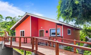 a red house with a large wooden deck at Home in Roatan in French Harbour