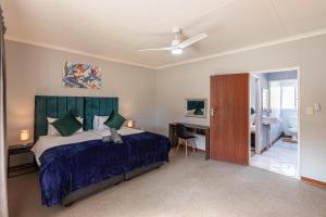 a bedroom with a bed and a desk and a table at Forest View Cottage in Muldersdrift