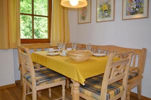 a dining room table with a yellow table cloth and chairs at Ferienresidenz Chiemseestrand - Apartment 14 in Chieming