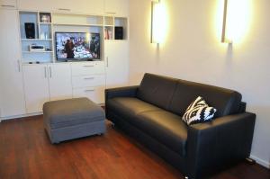 沙博伊茨Residenz Ostseestrand Ferienwohnung Nr 15 Meerblick的带沙发和搁脚凳的客厅