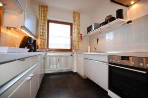 Una cocina grande con gabinetes blancos y una ventana. en Angelika, en Bernau am Chiemsee