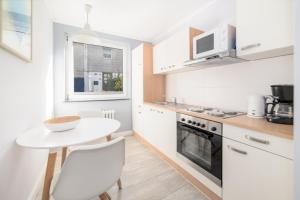una pequeña cocina con una mesa blanca y una encimera blanca en Haus Monika, en Helgoland
