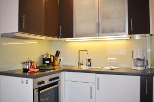 a kitchen with white cabinets and a sink at Chiemseenest in Prien am Chiemsee