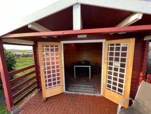a small house with a red roof and a patio at Ferienwohnungen Rügen mit Hund in Granskevitz
