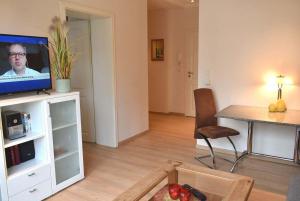 a living room with a television and a table with a chair at Seepassage Ferienwohnung Nr 02 in Timmendorfer Strand
