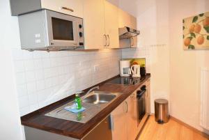 a small kitchen with a sink and a microwave at Seepassage Ferienwohnung Nr 02 in Timmendorfer Strand +10 photos