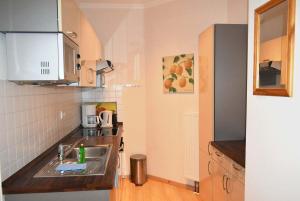 a small kitchen with a sink and a microwave at Seepassage Ferienwohnung Nr 02 in Timmendorfer Strand