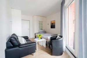 a living room with two chairs and a bed at MaJa in Norderney