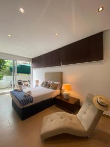 ein großes Schlafzimmer mit einem Bett und einem Stuhl in der Unterkunft Villa con piscina by MO in Málaga