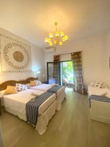 ein Schlafzimmer mit zwei Betten und einem Kronleuchter in der Unterkunft Villa con piscina by MO in Málaga + 42 Fotos