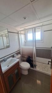 a bathroom with a toilet and a shower and a sink at Moraira Beach View in Moraira