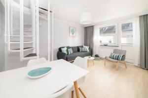 Una sala de estar con una mesa y sillas blancas. en Haus Monika, en Helgoland