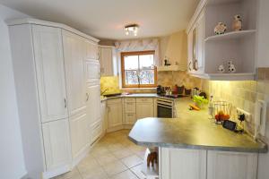 a kitchen with white cabinets and a window at Haus Nini in Chieming