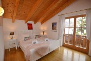 a bedroom with a white bed and a large window at Haus Nini in Chieming