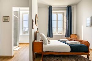 a bedroom with a bed and two windows at Château Féger 5 suites in Camblanes-et-Meynac