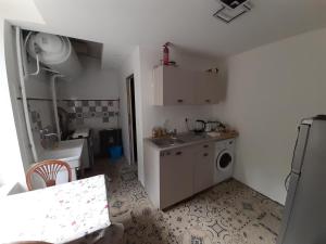 a small kitchen with a sink and a washing machine at L'idéïous in La GrandʼCombe +5 photos