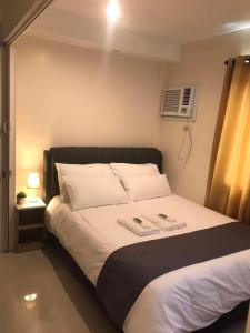 a bedroom with a bed with two towels on it at Persimmons Mabolo, Cebu City in Cebu City