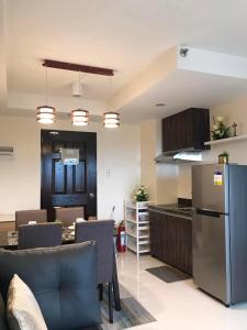 a kitchen and living room with a refrigerator and chairs at Persimmons Mabolo, Cebu City in Cebu City