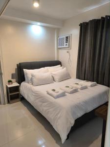 a bedroom with a bed with two towels on it at Persimmons Mabolo, Cebu City in Cebu City