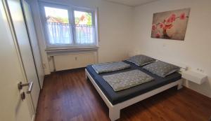 een slaapkamer met twee bedden en een raam bij FeWo Weishaupt in Tettnang