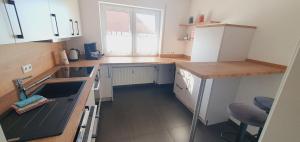een kleine keuken met een wastafel en een raam bij FeWo Weishaupt in Tettnang
