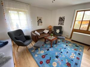 a living room with a couch and chairs and a blue rug at Ferienwohnungen im Feriendorf Reichenbach Nr 9 in Nesselwang