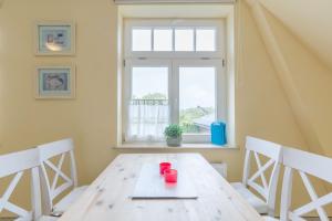 a dining room with a wooden table and a window at Haus Tarnewitz, Ferienwohnung 05 in Tarnewitz