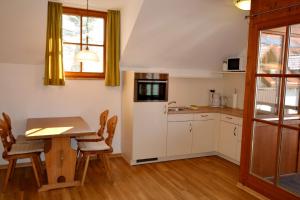 a kitchen with a table and a dining room at Ferienresidenz Chiemseestrand - Apartment 32 in Chieming