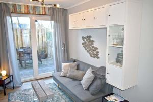 een woonkamer met een bank en een kast bij Lütt Hus an de See Ferienwohnung in Niendorf