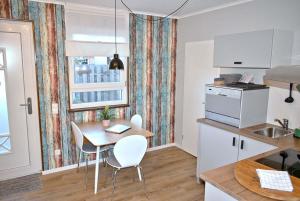 een keuken met een tafel en stoelen in een keuken bij Lütt Hus an de See Ferienwohnung in Niendorf