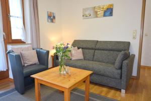 una sala de estar con un sofá y una mesa en Ferienresidenz Chiemseestrand - Apartment 28, en Chieming
