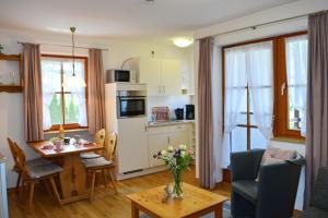 Una cocina y una sala con una mesa y un comedor. en Ferienresidenz Chiemseestrand - Apartment 28, en Chieming