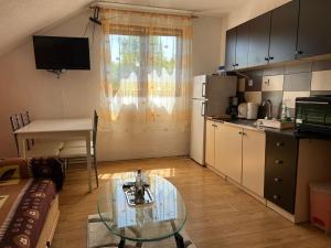 a small kitchen with a glass table in a room at Apartman Franjicic in Korenica