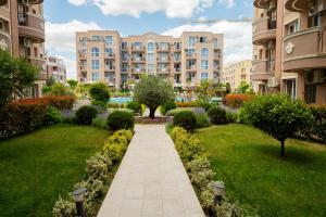 a walkway through a garden in a apartment complex at Marea Garden, Ravda - Studio with Pool by Flat Mаnager in Ravda