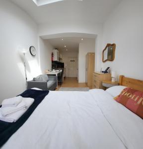 a bedroom with a large white bed and a living room at Oxford Luxury Flat in Oxford