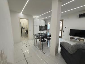 a white living room with a table and a couch at Apartments Lollipop in Novi Vinodolski