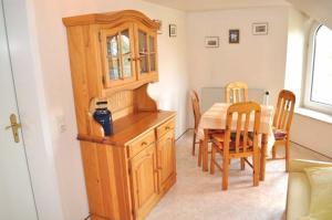 a dining room with a wooden cabinet and a table at Hof Kröger Ferienwohnung Nr 03 in Travemünde