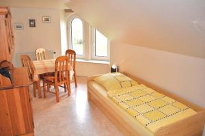 a bedroom with a bed and a table and chairs at Hof Kröger Ferienwohnung Nr 03 in Travemünde