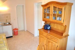 a kitchen with a wooden cabinet with a blue purse on it at Hof Kröger Ferienwohnung Nr 03 in Travemünde +5 photos