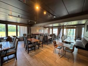 a dining room with tables and chairs and windows at Vossestølen Hotel in Vossestrand