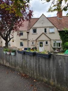 a house with a fence with raised garden boxes on it at Oxford Luxury Flat in Oxford