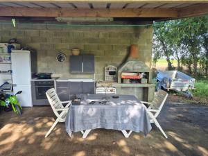 a kitchen with a table and chairs and a stove at Le petit campîng de Vallye in Maxent