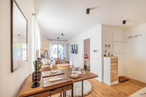 a kitchen and living room with a wooden table at Villa Chloe Binz - App 1 am Kurpark, Binz Exquisit in Binz