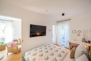 a living room with a couch and a tv on a wall at Villa Chloe Binz - App 1 am Kurpark, Binz Exquisit in Binz
